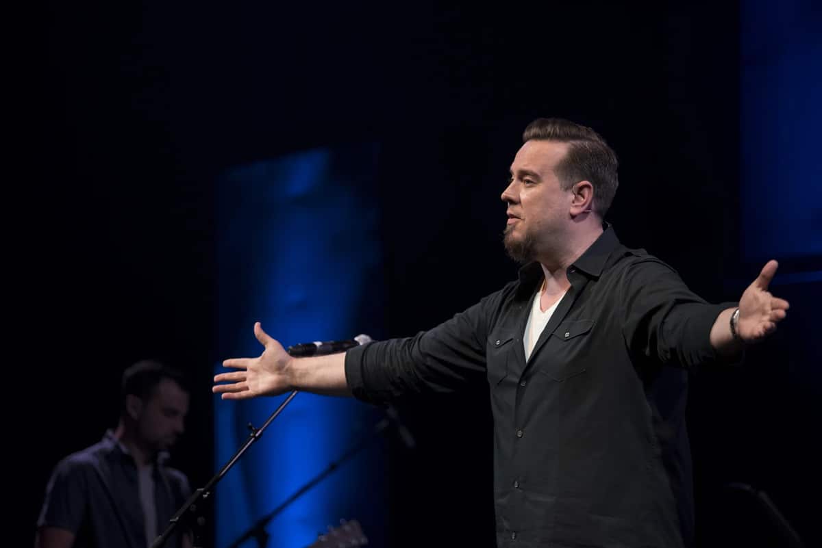 Cliff Johnson teaches onstage with his arms open